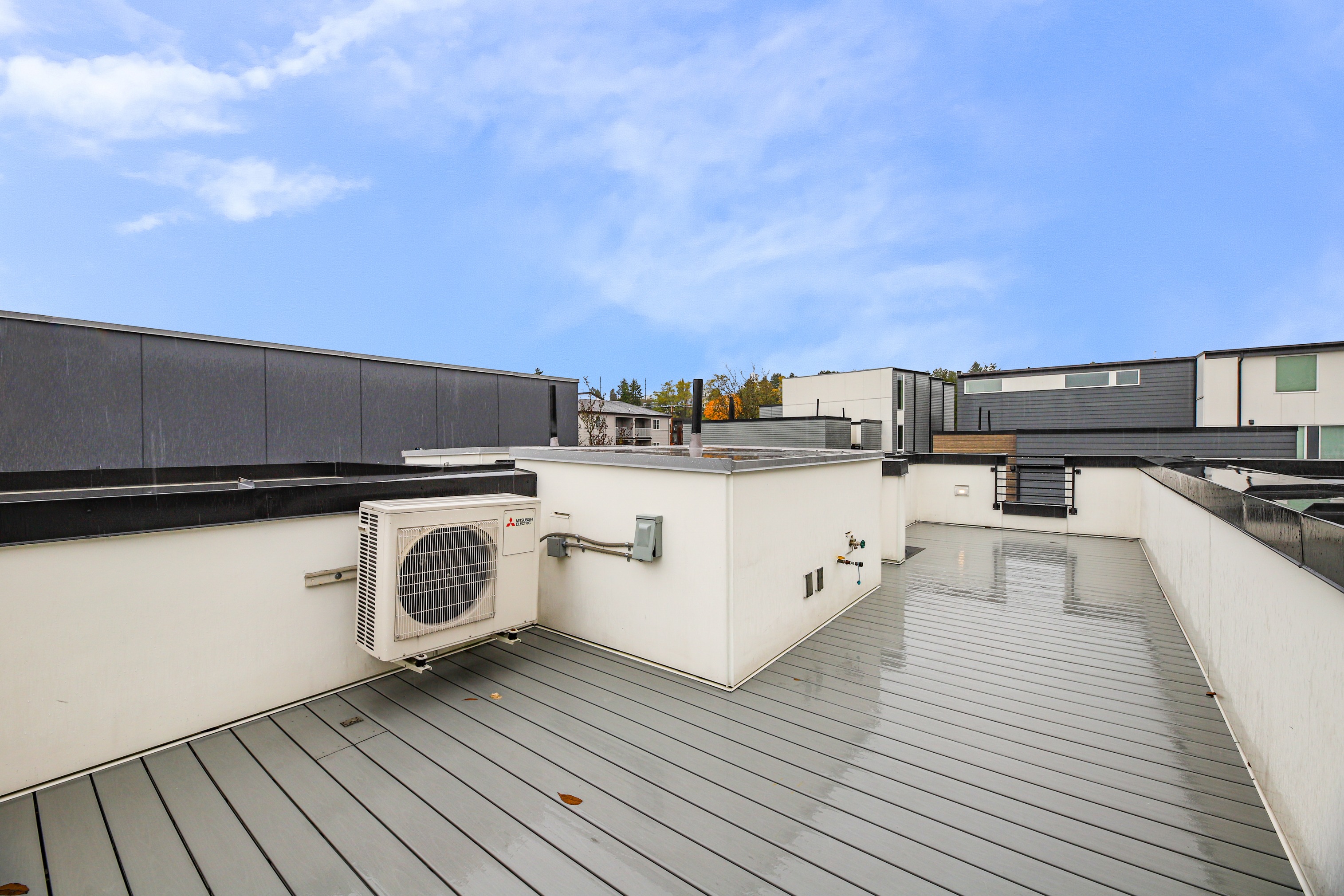 Spacious rooftop deck with gray composite decking and city views